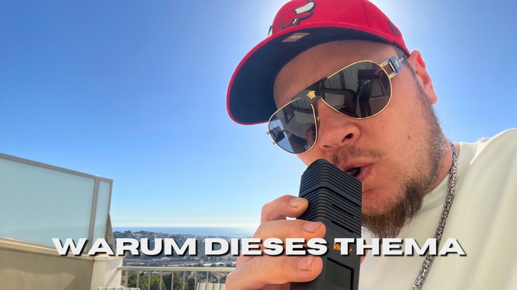 Mann mit roter Cap, Sonnenbrille und Kette nutzt einen Vaporizer auf einem sonnigen Balkon mit Stadtblick im Hintergrund. Text im Bild: „WARUM DIESES THEMA“.